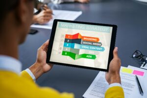 black man holding a tablet and reviews charts and analyzing the data about digital marketing Trends and it's campaigns to SEO the campaign in United States.